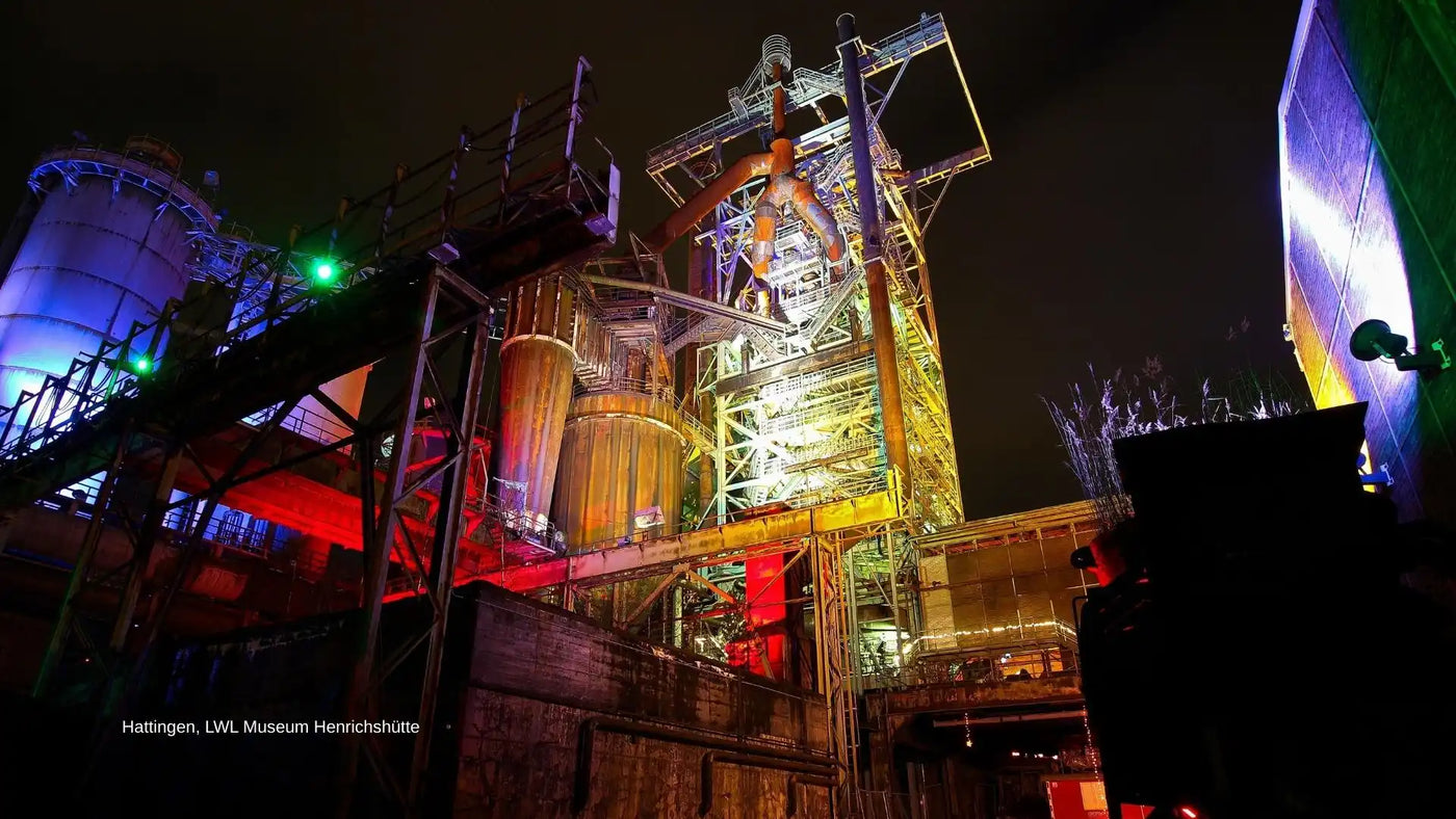 Industrielles Gelände mit bunter Nachtbeleuchtung.